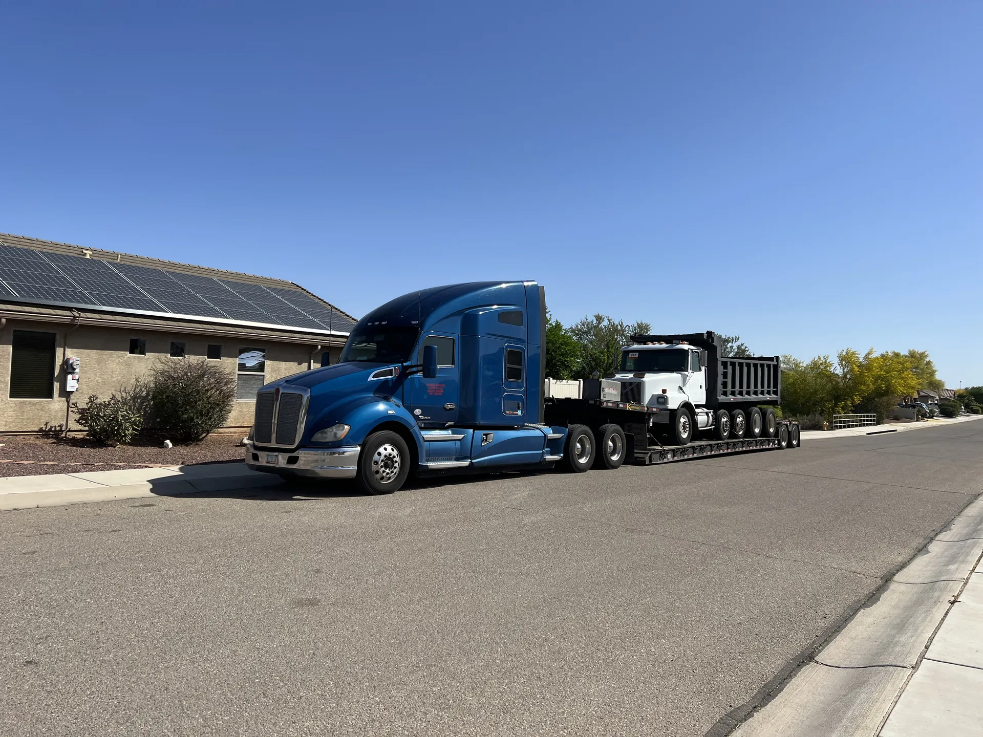 Patriot Services Kenworth hauling dump truck on lowboy trailer