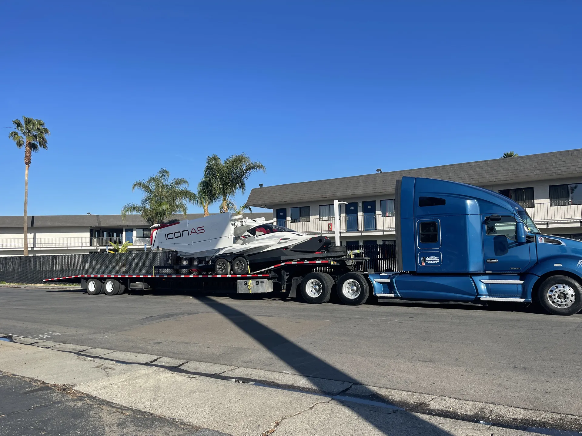 Patriot Services Kenworth hauling boat on flatbed